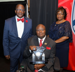 Photo of Edward Mitchell with his mother and father at an awards ceremony.