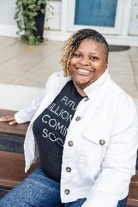 Headshot of Ruby Sunshine-Taylor, a Black woman with short hair, smiling for the camera